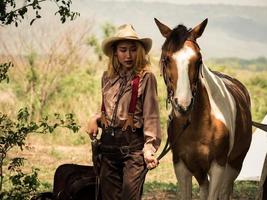 cowgirl en het paard zijn diep met elkaar verbonden in de liefde vanwege hun verontruste relaties in een wilde bandiet foto