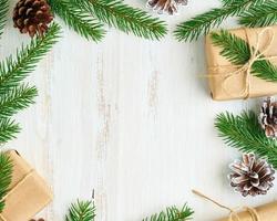 kerstmis en gelukkig nieuwjaar geen afval houten achtergrond. handgemaakte kerstcadeaudoos, dennentakken, ambachtelijk papier, bovenaanzicht, kopieerruimte. milieuvriendelijk plasticvrij concept foto