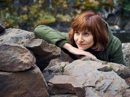 jonge vrouw bewondert de noordelijke natuur. persoon op de achtergrond van rotsen, stenen, wild bos foto