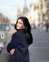 portret f mooie intelligente brunette die door de straat van sint-petersburg in het stadscentrum loopt. charmante bedachtzame vrouw met lang donker haar dwaalt alleen rond, ondergedompeld in gedachten foto