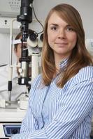 vrouwelijke opticien die mannelijke cliënt oogonderzoek geeft foto