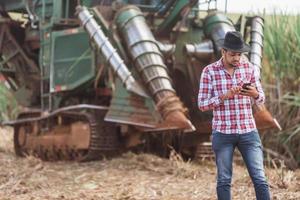 landelijke zakenman die het werk controleert. suikerriet oogstmachine. boer. foto