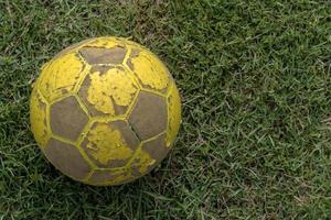 close-up van oude voetbal die op gras ligt. foto