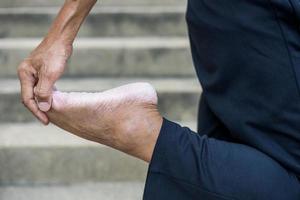 close-up van de hand van een thaise man die staat en zijn voeten buigt. foto