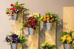 kunstbloemen in potten aan de muur. foto