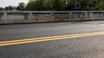 close-up achtergrond van een nieuw asfalt wegdek met gele strepen. foto