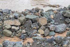 granieten stapel op de grond in de buurt van de oever van de rivier. foto