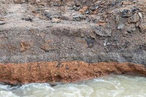 water onder de verharde weg weggesleten. foto