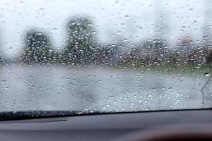 regendruppels op de voorruit met de weg. foto
