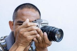 geïsoleerde close-up van een Thaise man met een grote dslr-filmcamera met een zwarte zoomlens. foto