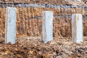 grote betonnen palen en grondlagen onder de verharde weg. foto