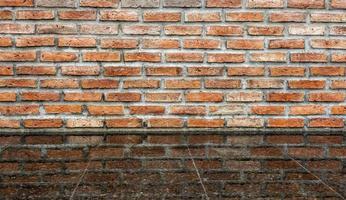 oude bakstenen muur achtergrond met water reflectie op terrazzo tegelvloer. foto