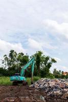 backhoe in de buurt van een stapel stenen. foto