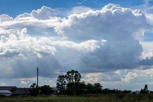 bewolkte wolken in de lucht boven de bomen die op het platteland van thailand leven. foto