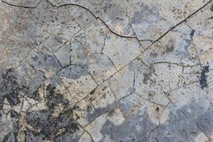grijze cement betonnen muur met scheuren en schimmel textuur achtergrond foto