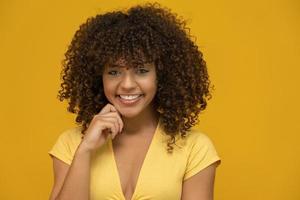 Afro-Amerikaanse vrouw met afro kapsel en glamour glamour make-up. gele achtergrond. foto