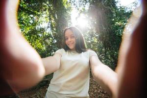 portret van een lachend jong meisje dat een selfie-foto maakt in het park foto