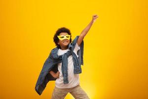 portret van een jonge jongen van gemengd ras, verkleed als superheld. zwarte baby in superheldenkostuum. het winnaar- en succesconcept. foto