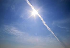 condensatiesporen van vliegtuigen in de blauwe lucht tussen enkele wolken foto