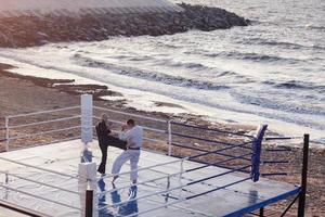 karatevechters vechten 's ochtends op de boksring op het strand foto