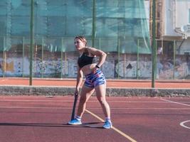 jonge sterke vrouw die in de zomer buiten traint, vrouwelijke professionele atleet doet oefeningen in het park foto