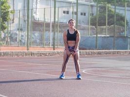 jonge sterke vrouw die in de zomer buiten traint, vrouwelijke professionele atleet doet oefeningen in het park foto