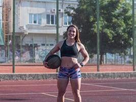 jonge sterke vrouw die in de zomer buiten traint, vrouwelijke professionele atleet doet oefeningen in het park foto