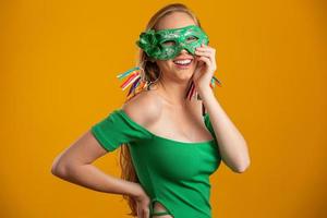 mooie vrouw gekleed voor carnaval nacht. lachende vrouw klaar om te genieten van het carnaval met een kleurrijk masker. foto