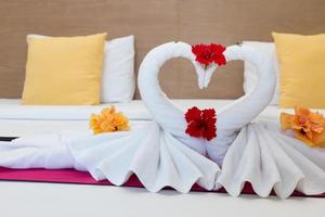 witte zwanen gemaakt van handdoeken op bed in het hotel foto