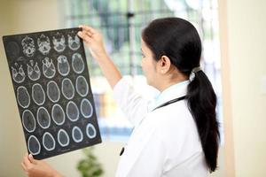 vrouwelijke arts die een hersenen geautomatiseerde scan onderzoekt