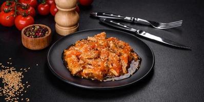 teriyaki kip met saus, sesam, kruiden en specerijen op een donkere achtergrond foto