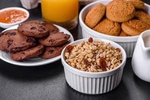 heerlijk voedzaam gezond ontbijt met granola, eieren, haverkoekjes, melk en jam foto