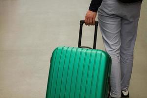 wachten op de luchthaven. het concept van zomervakantie, een reiziger met een koffer in de wachtruimte van de luchthaventerminal. selectieve aandacht. foto