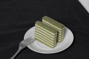 originele laagcake met pandan-smaak. layer cake is klaar om je ochtend te begeleiden met een glas thee. Indonesische taart. we zien het vaak als bijgerecht tijdens eid. zoete en zachte taart. focus vervagen. foto