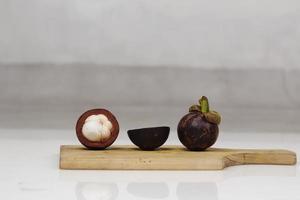 mangosteen is een tropische vrucht uit Azië. mangosteen heeft een kenmerkende zoetzure smaak. mangosteen heeft ook een groot aantal voordelen, eigenschappen en voedingswaarde die nuttig is voor de gezondheid. foto