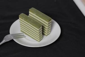 originele laagcake met pandan-smaak. layer cake is klaar om je ochtend te begeleiden met een glas thee. Indonesische taart. we zien het vaak als bijgerecht tijdens eid. zoete en zachte taart. focus vervagen. foto