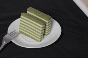 originele laagcake met pandan-smaak. layer cake is klaar om je ochtend te begeleiden met een glas thee. Indonesische taart. we zien het vaak als bijgerecht tijdens eid. zoete en zachte taart. focus vervagen. foto