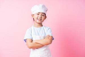 afbeelding van Aziatisch kind dat oefent om chef-kok te worden foto