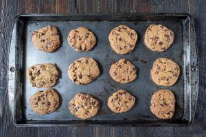 platliggende metalen bakplaat van gebakken chocolate chip cookies foto