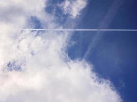 jet witte rook in de wolken blauwe lucht foto