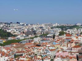 een vliegtuig boven het rode dak van de stad Lissabon Portugal foto
