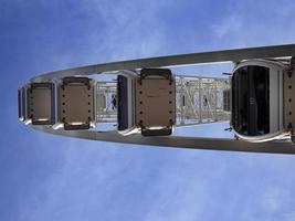 oprijzende weergave van reuzenrad gigantische cabineauto onder de blauwe lucht foto