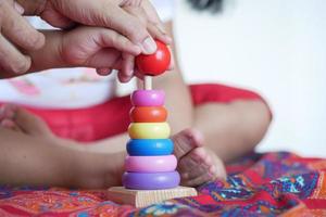 kind spelen met een baby speelgoed op bed, kind ontwikkelingsconcept. foto