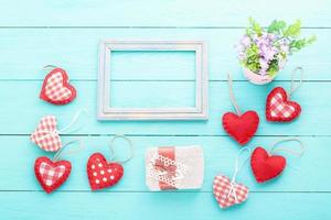 Valentijnsaccessoires en vaas met bloemen op blauwe houten tafel. bovenaanzicht foto