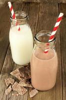 chocolade en gewone melk in flessen op hout