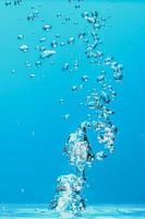 abstracte achtergrondafbeelding van bellen in water. schoon water met waterdruppels en golven. zoet water een glas met bubbels blauwe achtergrond. foto