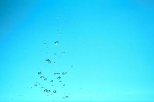 abstracte achtergrondafbeelding van bellen in water. schoon water met waterdruppels en golven. zoet water een glas met bubbels blauwe achtergrond. foto