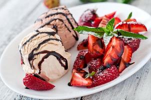 ijs met aardbeien en chocolade op een witte plaat foto