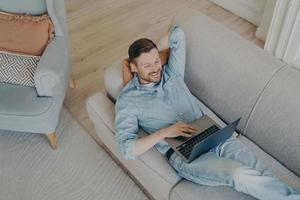 jonge bedrijfsmedewerker in vrijetijdskleding ontspannen na succesvolle online presentatie foto