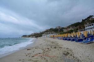 strand met ligbedden bij slecht weer foto